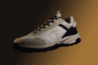 a pair of white and black sneakers on a brown background