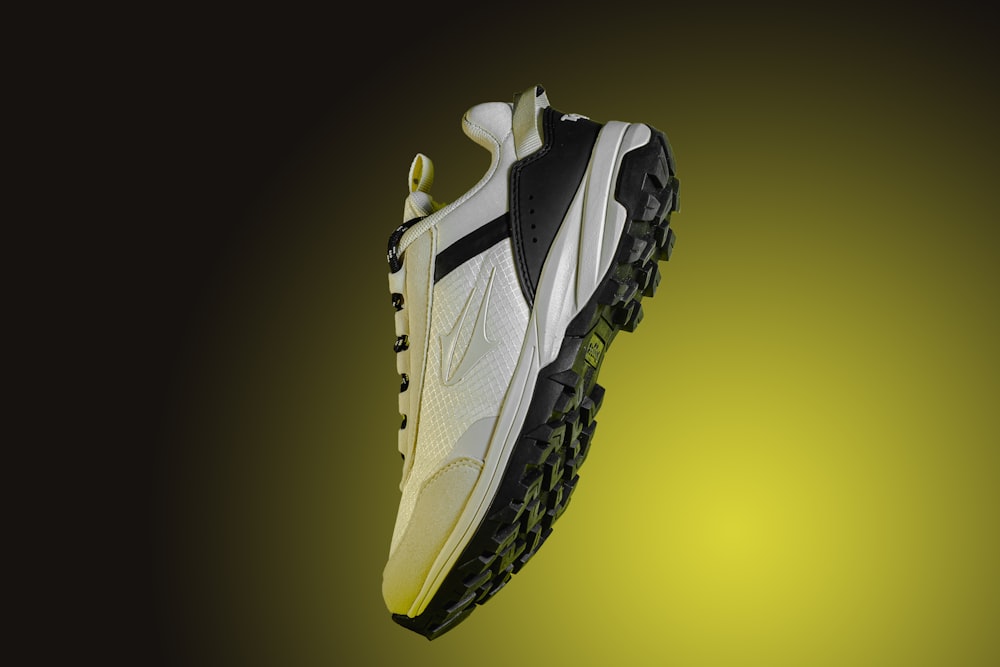 a white and black shoe with yellow accents