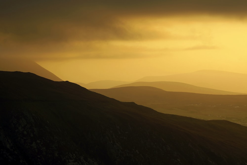 the sun is setting over the mountains in the distance