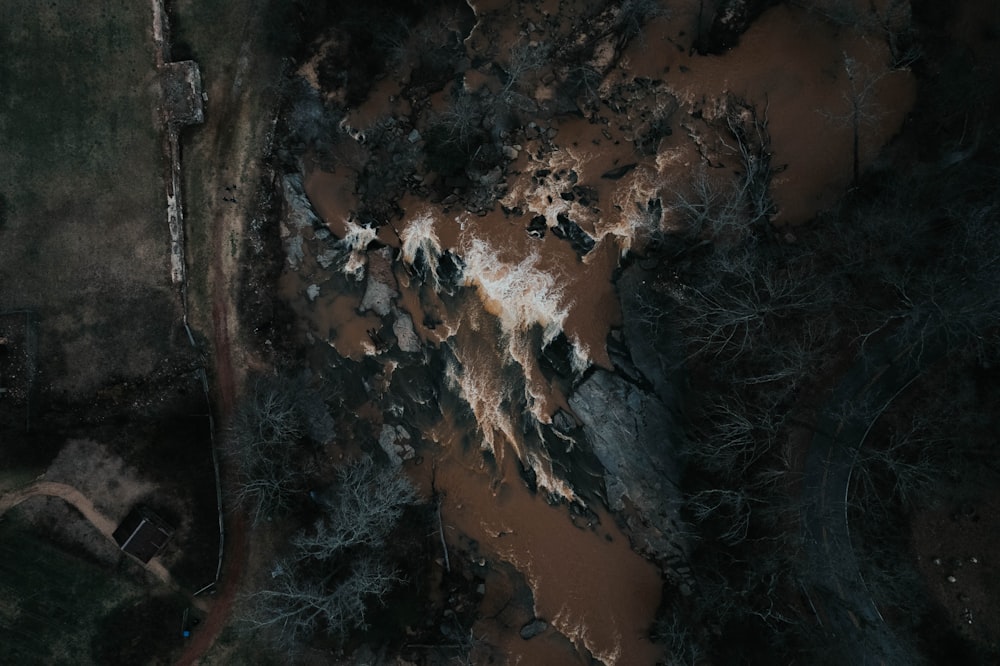 an aerial view of a muddy field with trees