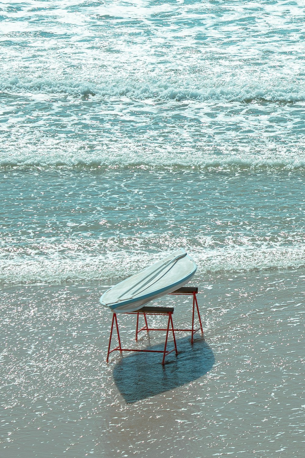 a surfboard sitting on top of a table on a beach