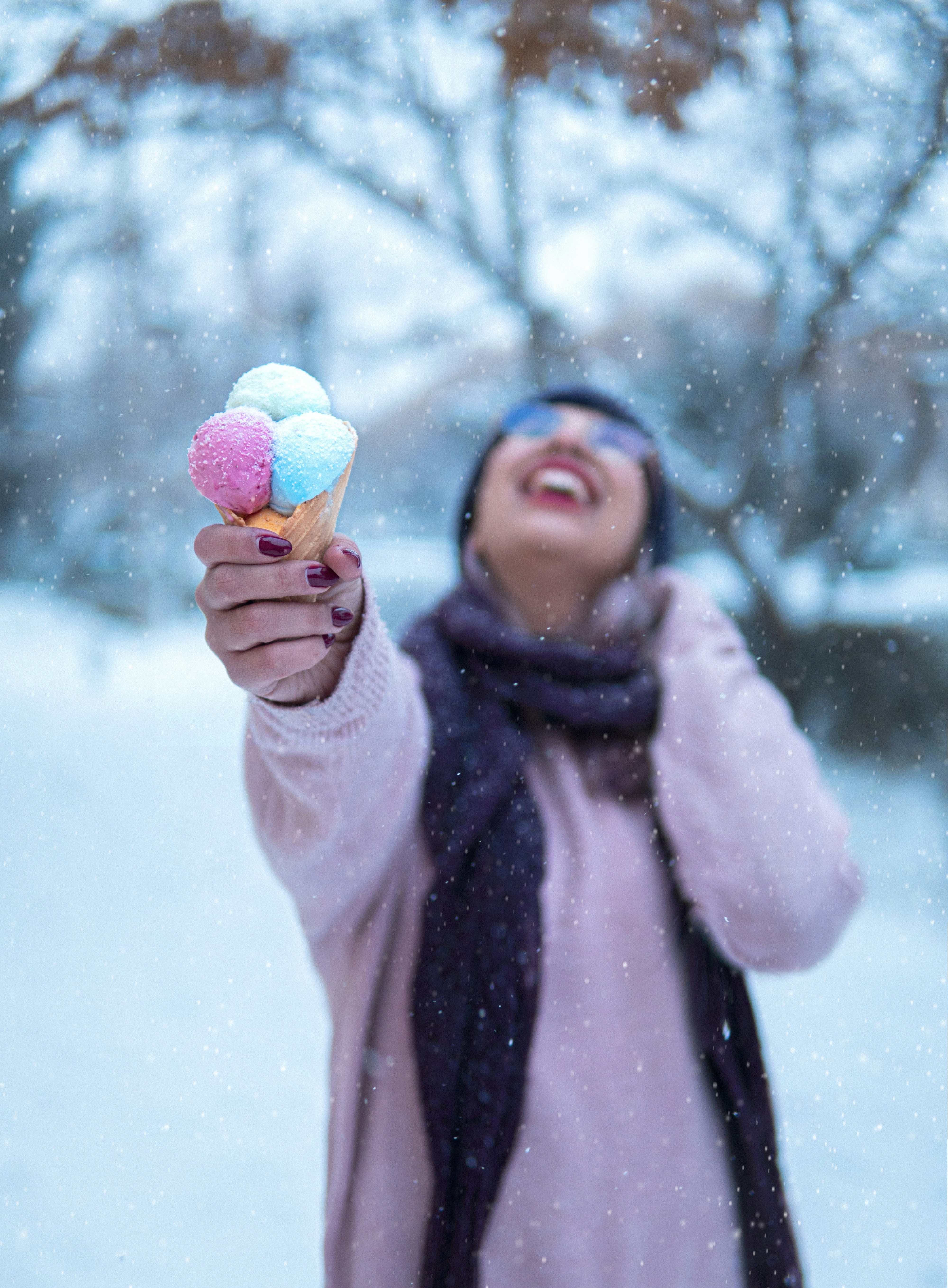 a woman holding up two ice cream cones