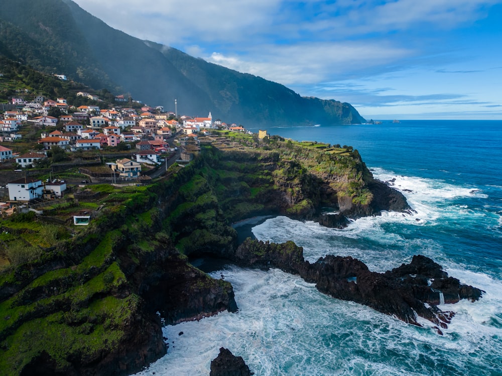 a scenic view of a village on a cliff by the ocean