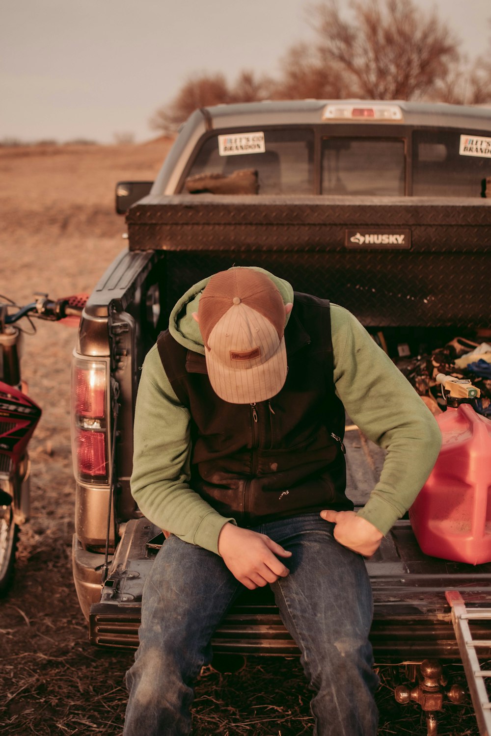 a man sitting on the back of a pickup truck