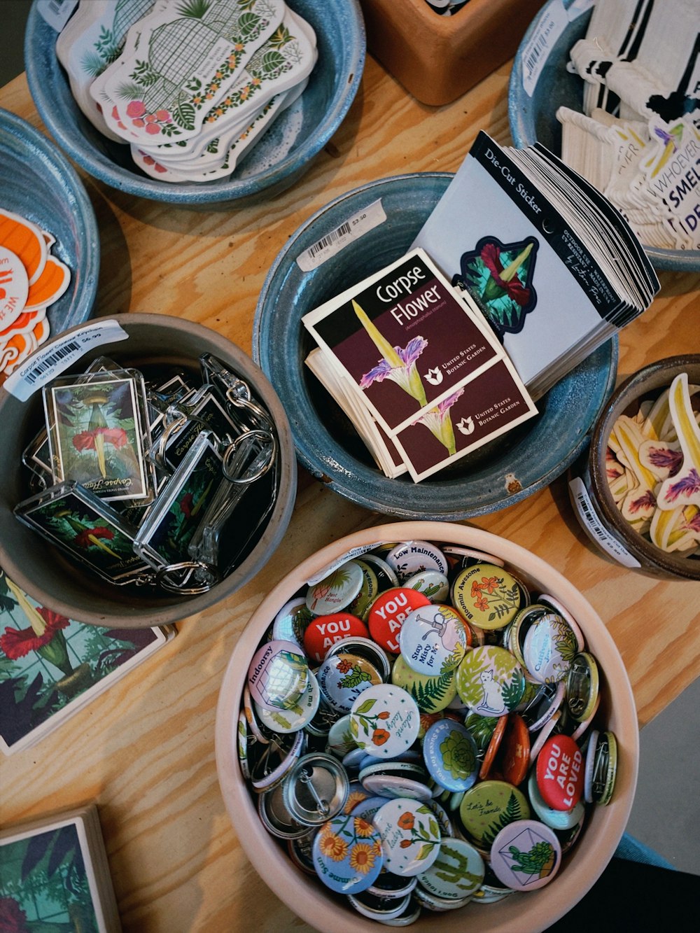 a wooden table topped with plates and bowls filled with buttons