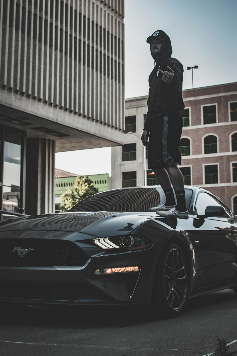 a man standing on the hood of a car