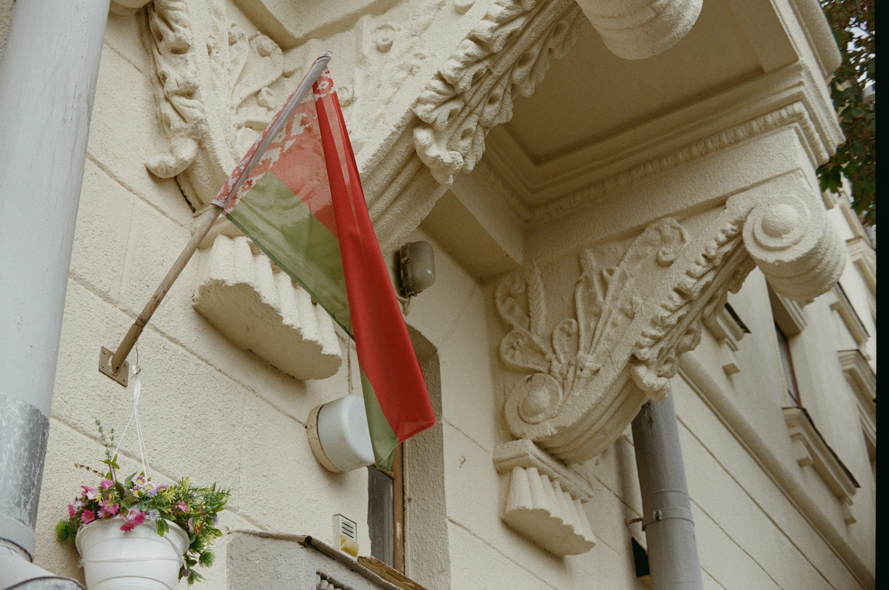 a red and green flag hanging from the side of a building