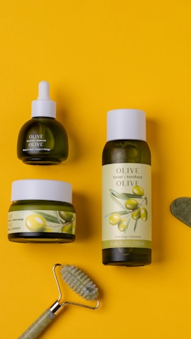 three bottles of olive oil and a toothbrush on a yellow background