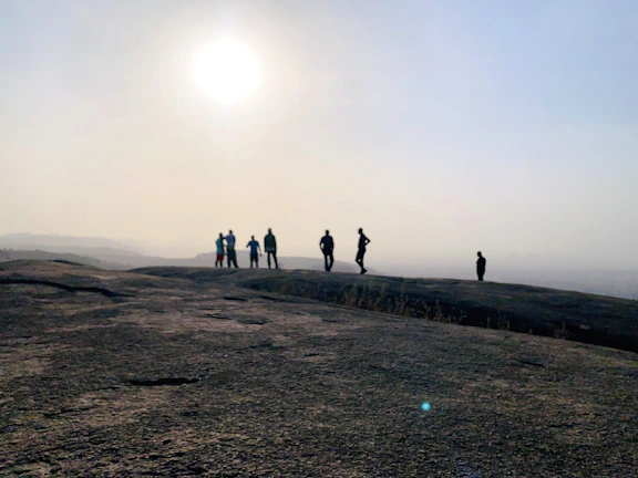 A smiling pioneer teaching a small group outdoors with Mount Sinai softly glowing in the background