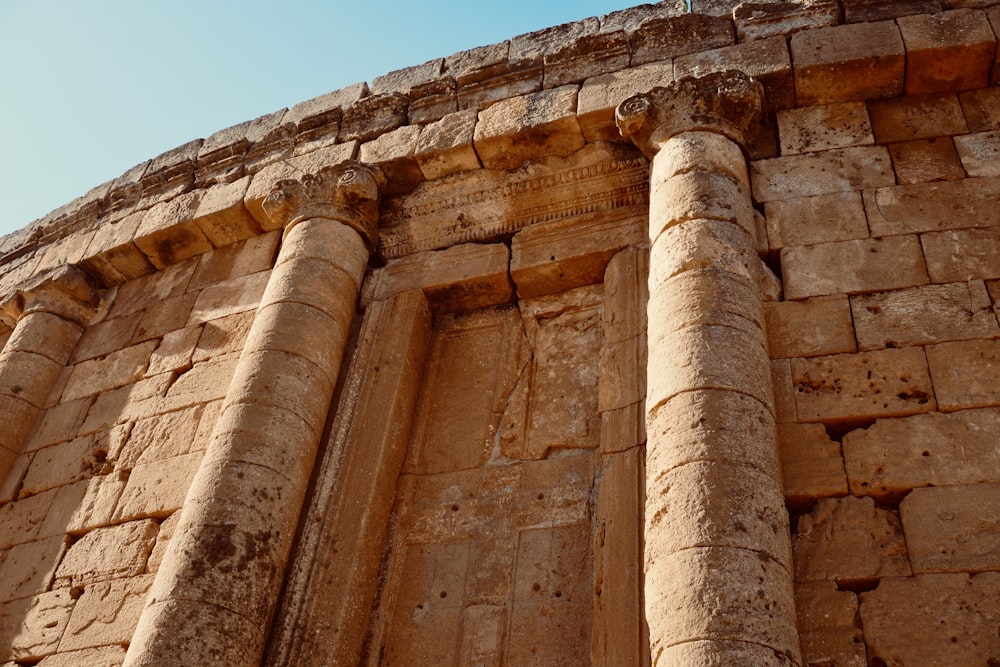 a tall stone building with two large pillars