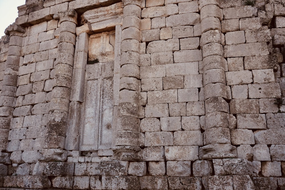 un muro de piedra con una ventana y una puerta