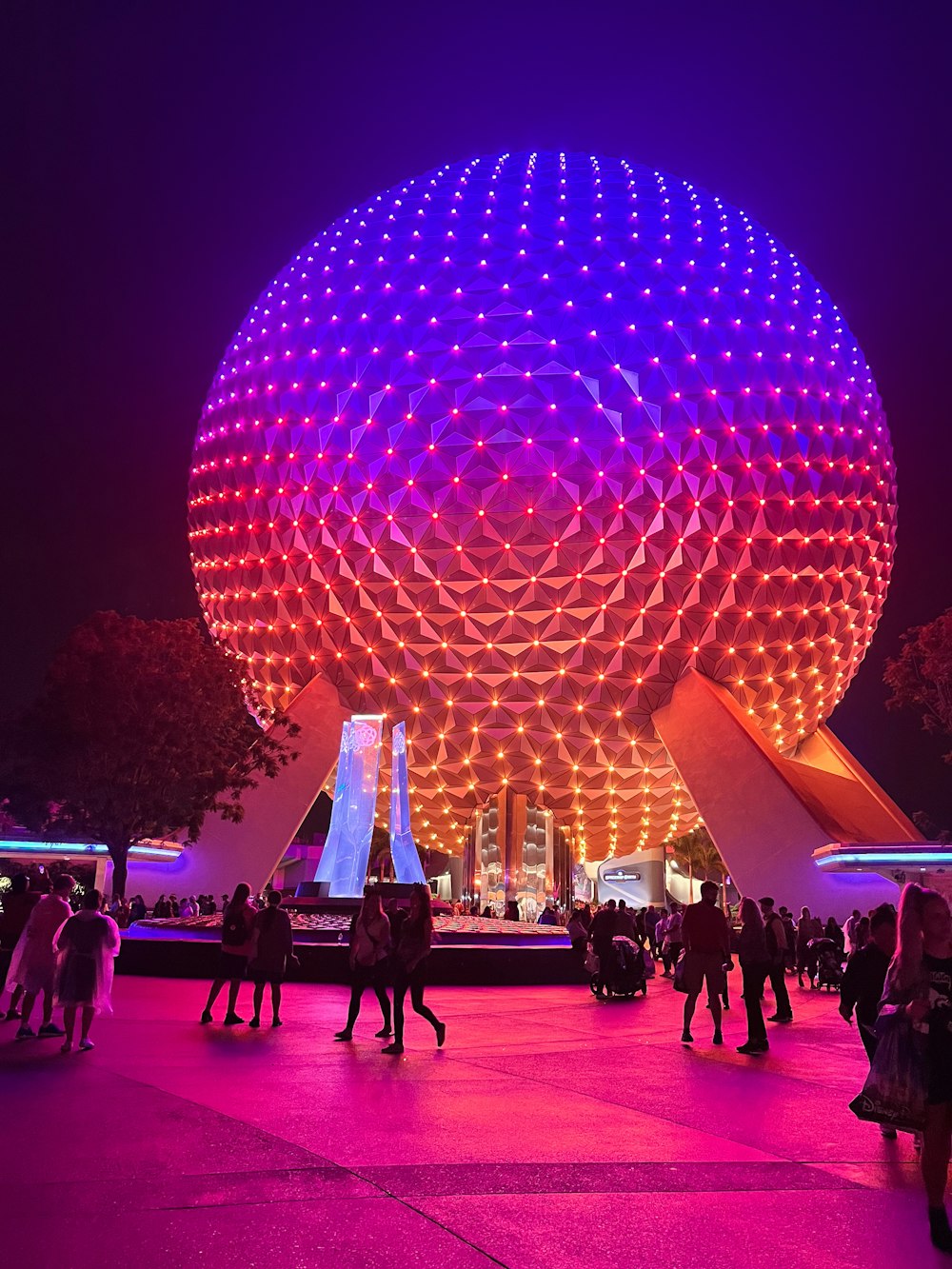 people are walking around in front of a large ball