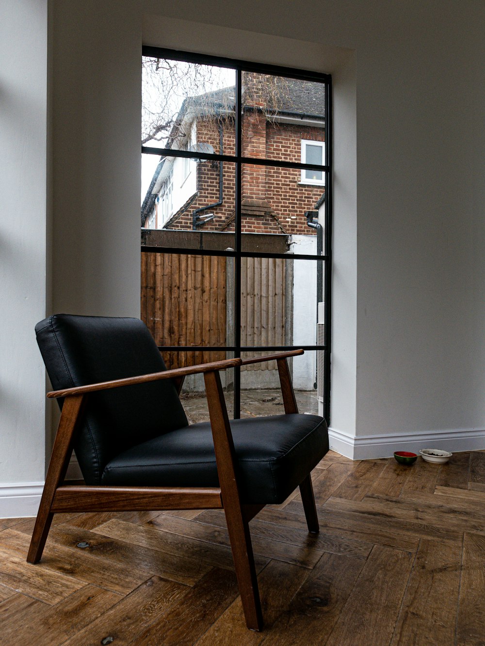 a chair sitting in front of a window on a hard wood floor