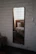 Elegant custom-cut mirror reflecting a cozy, stylish bedroom interior with soft lighting.