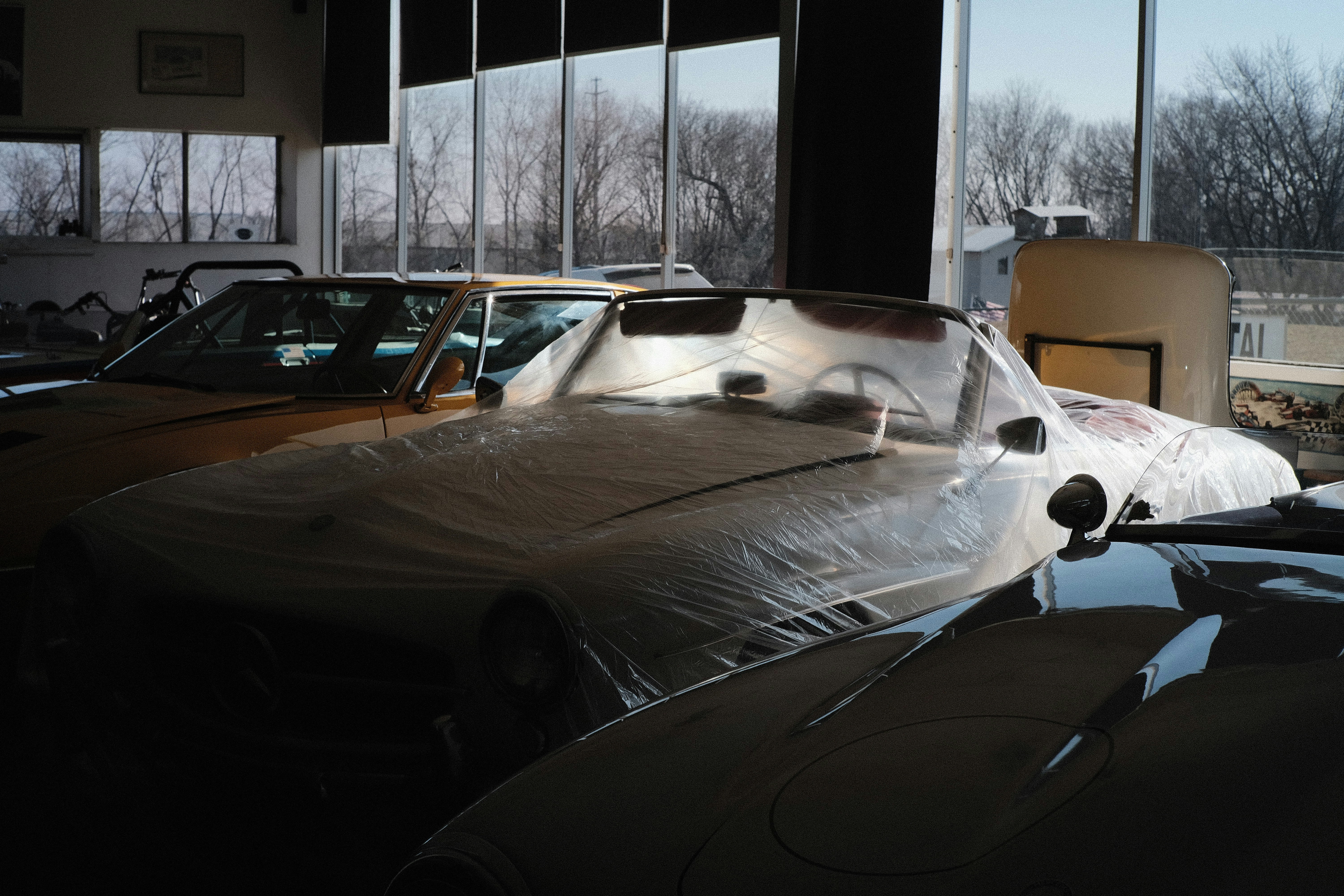 A car covered in plastic in a garage