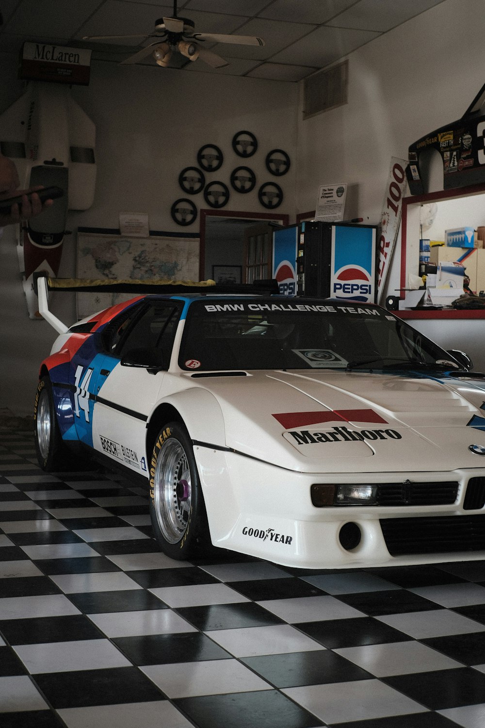 a white race car sitting on top of a checkered floor