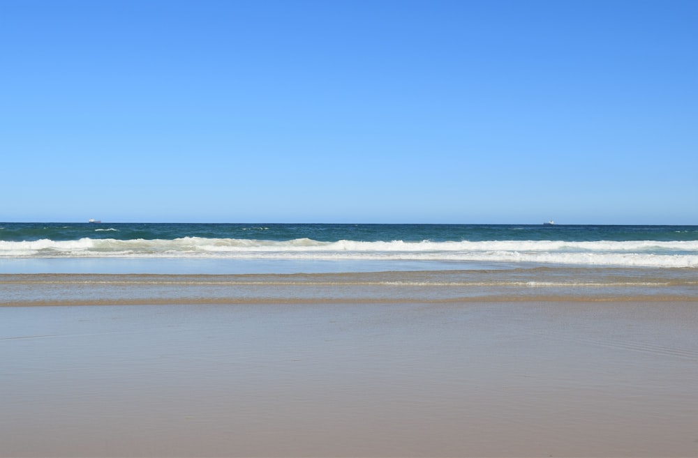 a person walking on the beach with a surfboard