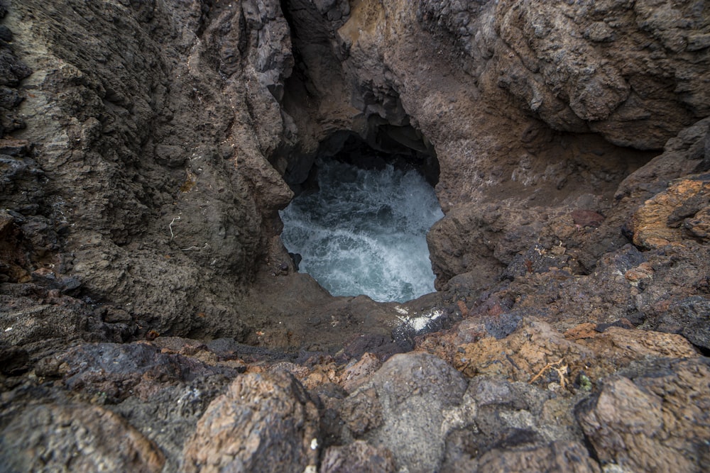 a hole in the rocks with water coming out of it