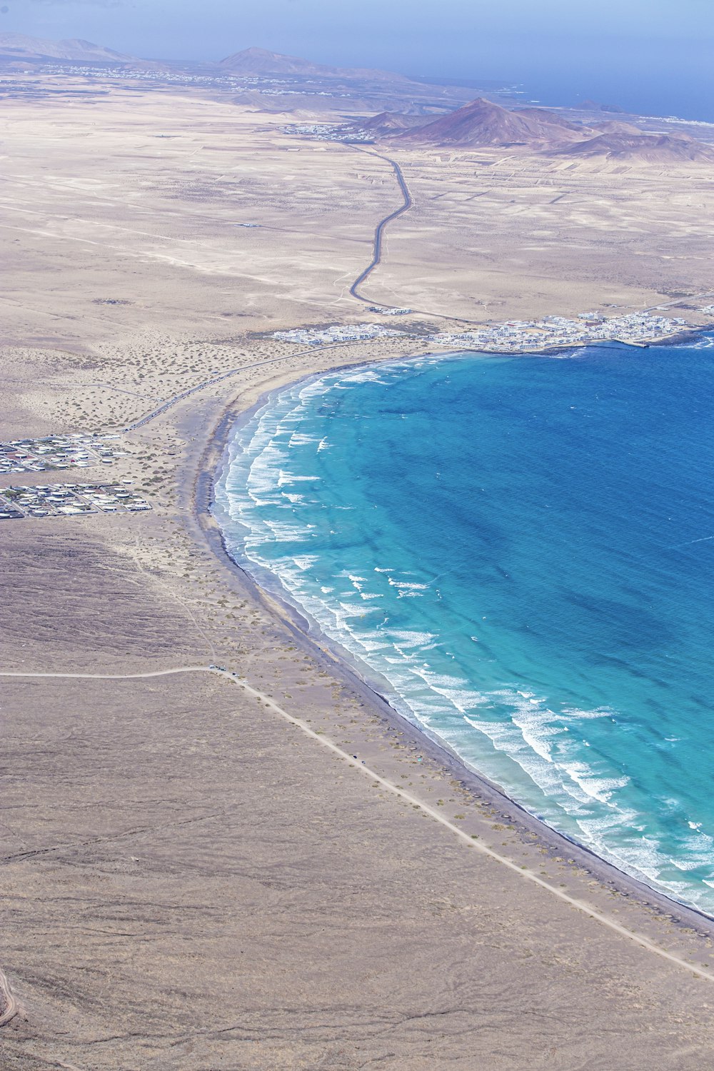 a large body of water sitting next to a sandy beach