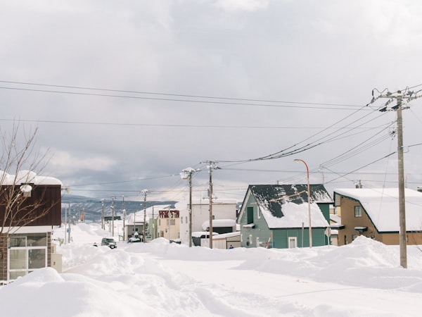 A snow covered street with power lines overhead