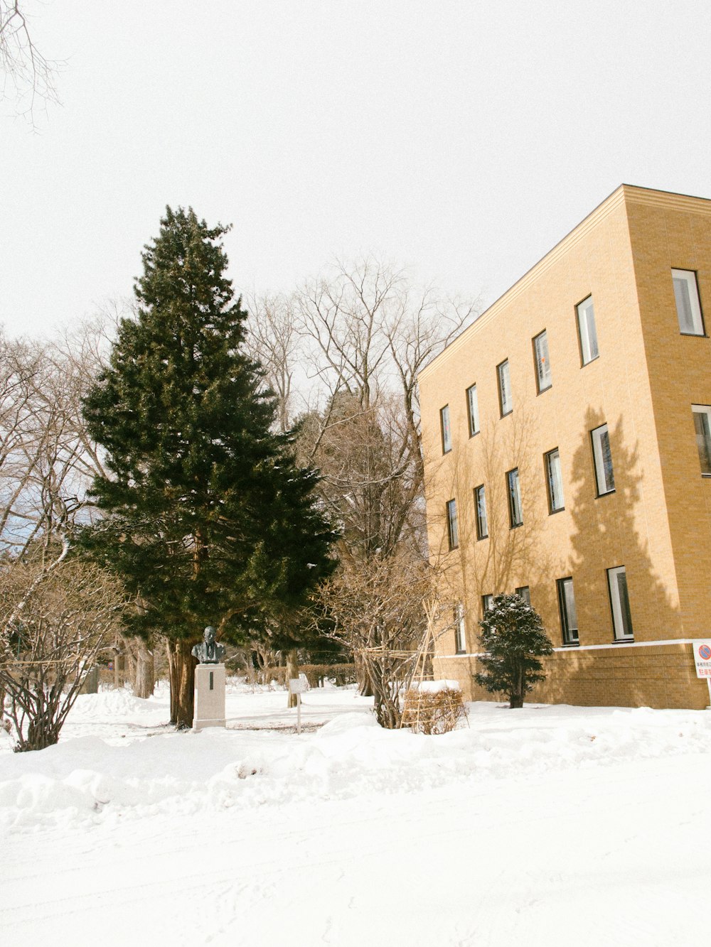 a snow covered street with a building in the background