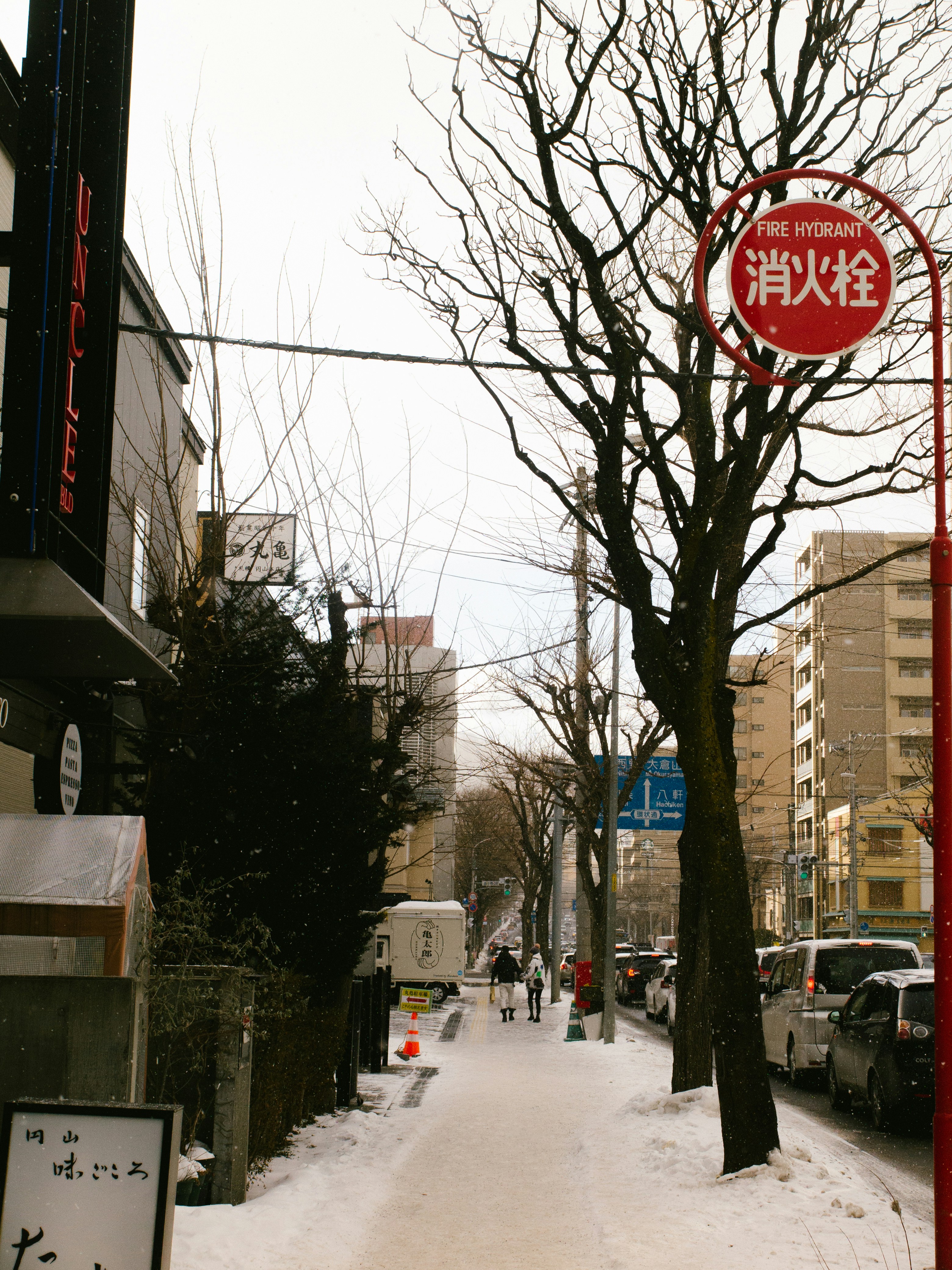 A snowy street with cars parked on the side of it photo – Free Japan ...