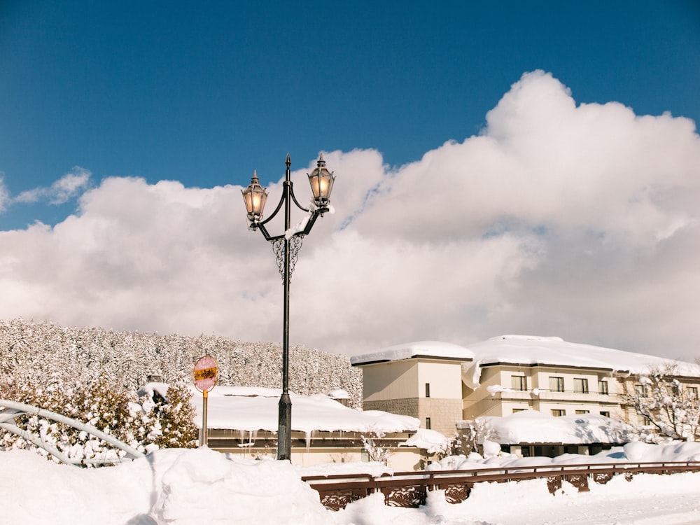 a street light covered in snow next to a building