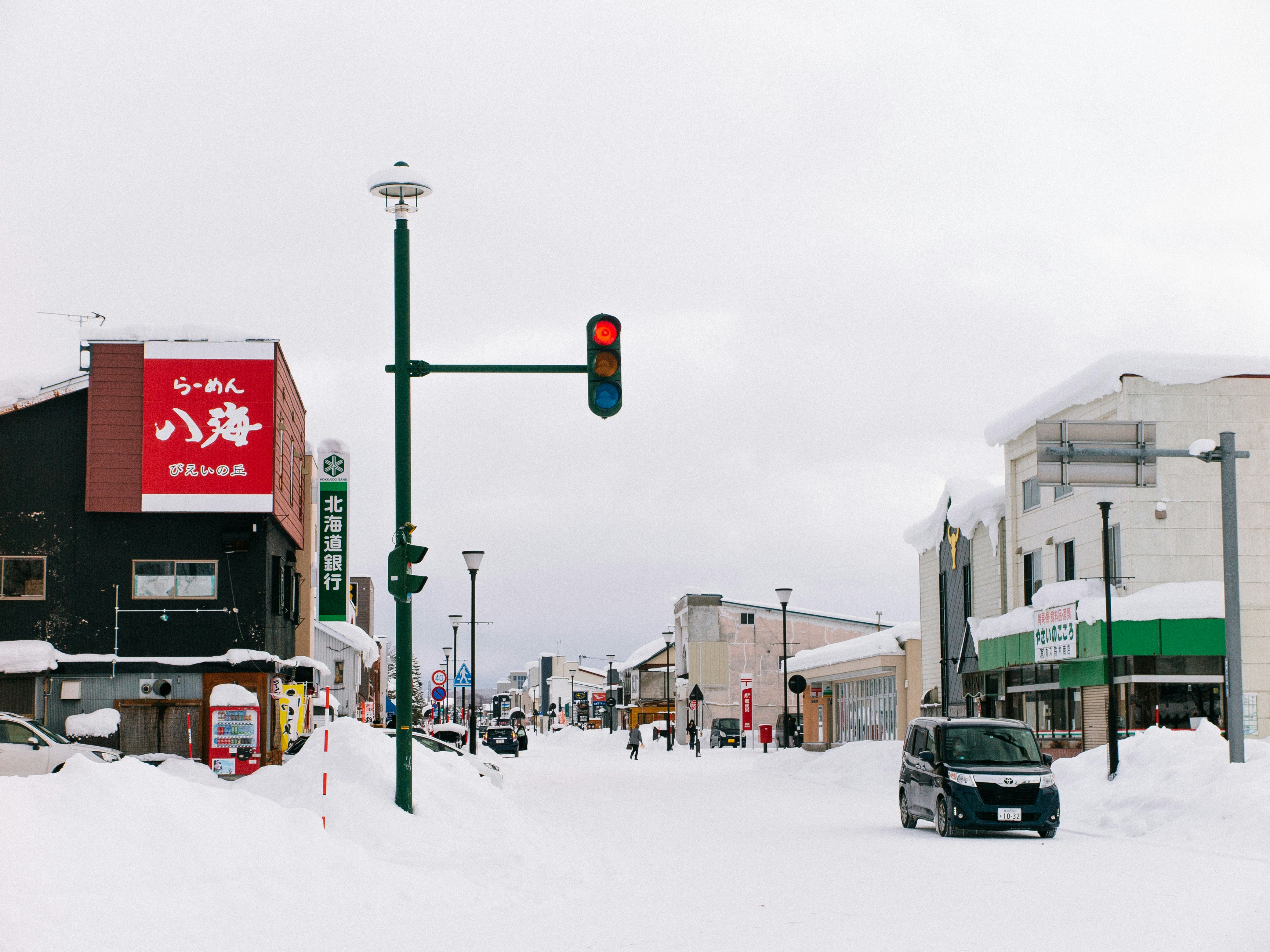 Un coche conduciendo por una calle cubierta de nieve