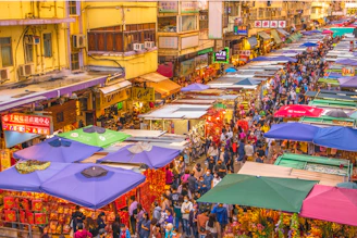 a crowded street filled with lots of colorful tents