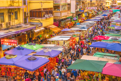 a crowded street filled with lots of colorful tents