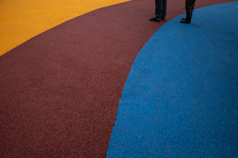 Two colorways of rubber safety surfacing meeting in a curve