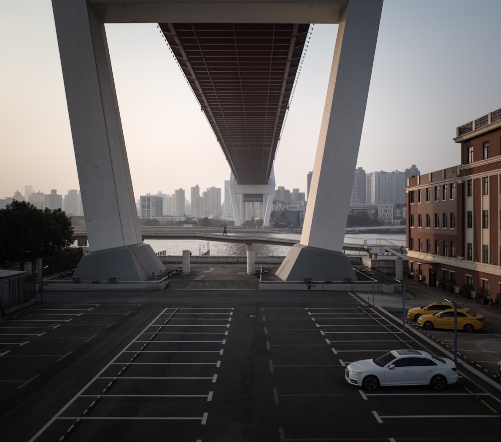 a car parked in a parking lot under a bridge