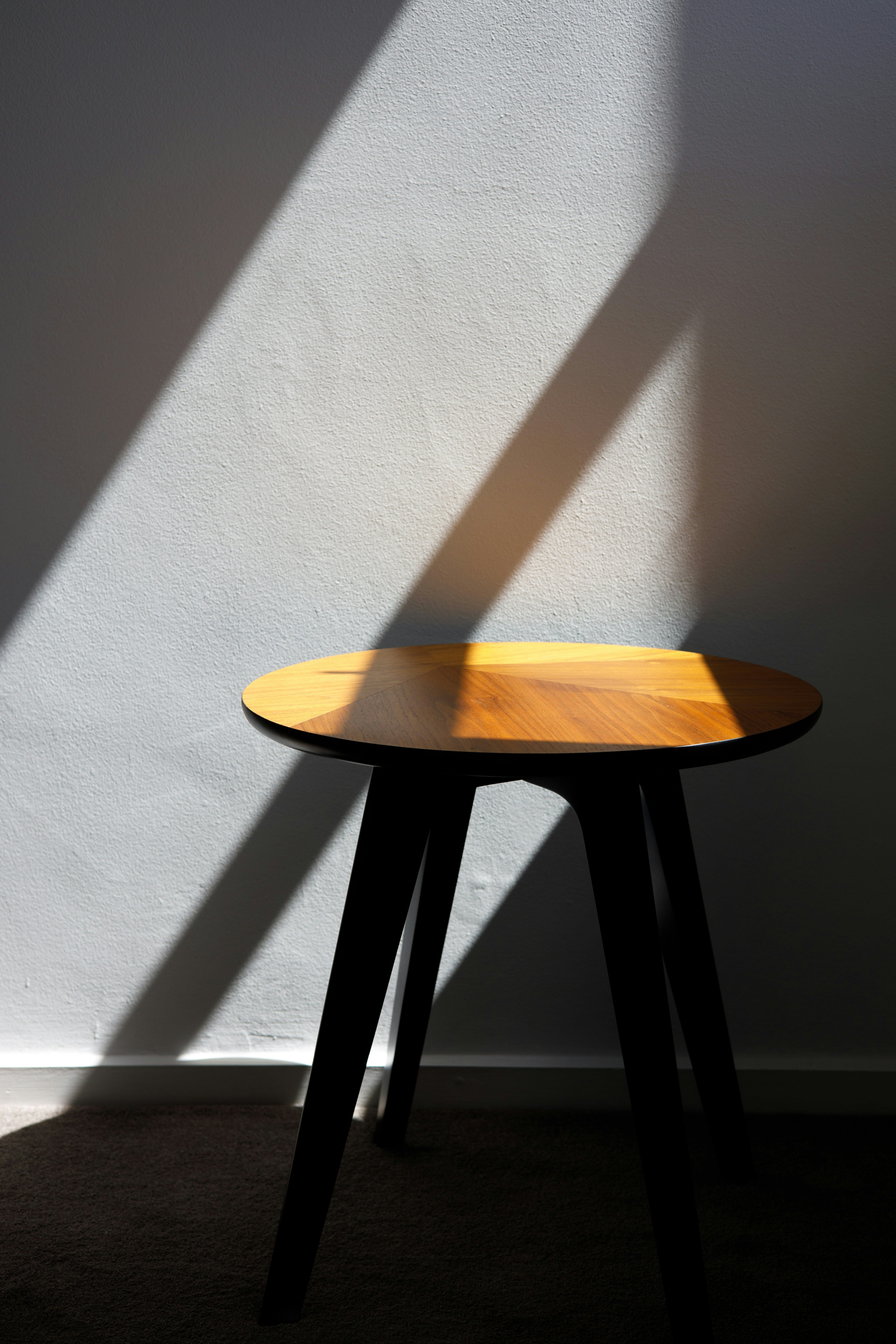 a wooden table with a shadow on the wall photo – Free Image on Unsplash