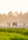 Children playing soccer on a sunny school field with mountains in the background.