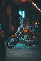 Close-up of a custom neon-lit bike engine glowing electric blue in a dark urban alley.