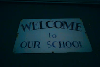 The school principal warmly greeting students at the entrance.