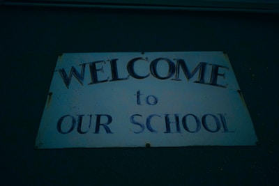 A friendly school administrator welcoming new students with a smile.