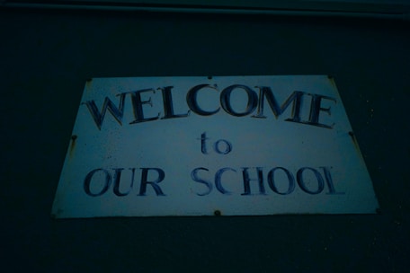 A friendly admissions counselor warmly greeting a family at the school entrance.