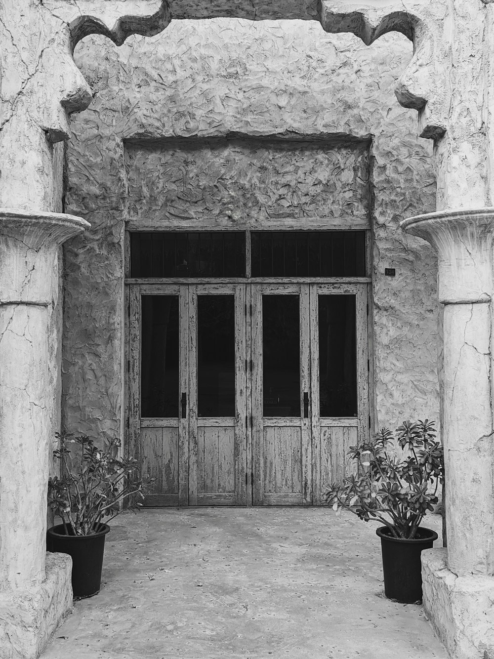a black and white photo of a building with two doors