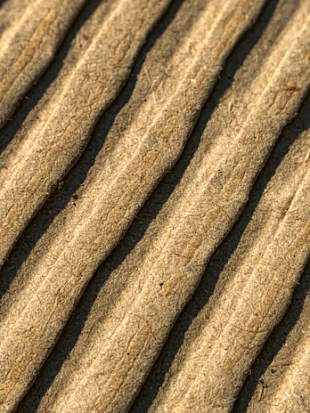 Side view of a cardboard plate displaying its thickness and premium finish against a white backdrop.