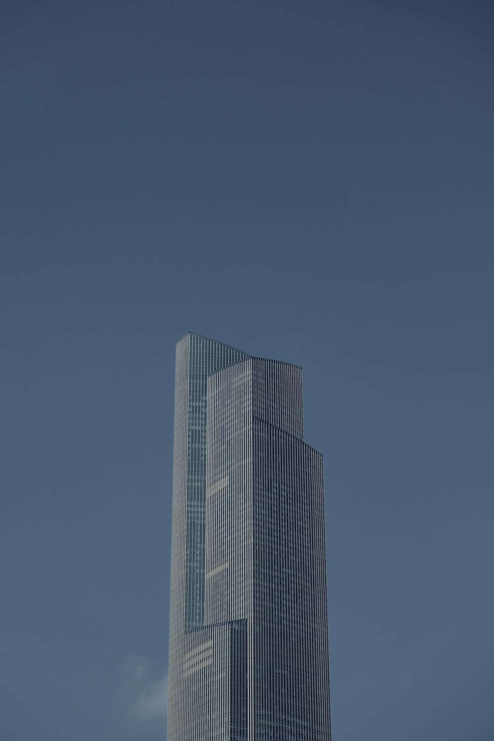 a tall building with a plane flying in the sky