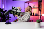 a woman sitting at a table holding a movie clapper