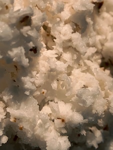 A close-up of tartar crystals on a wooden surface.