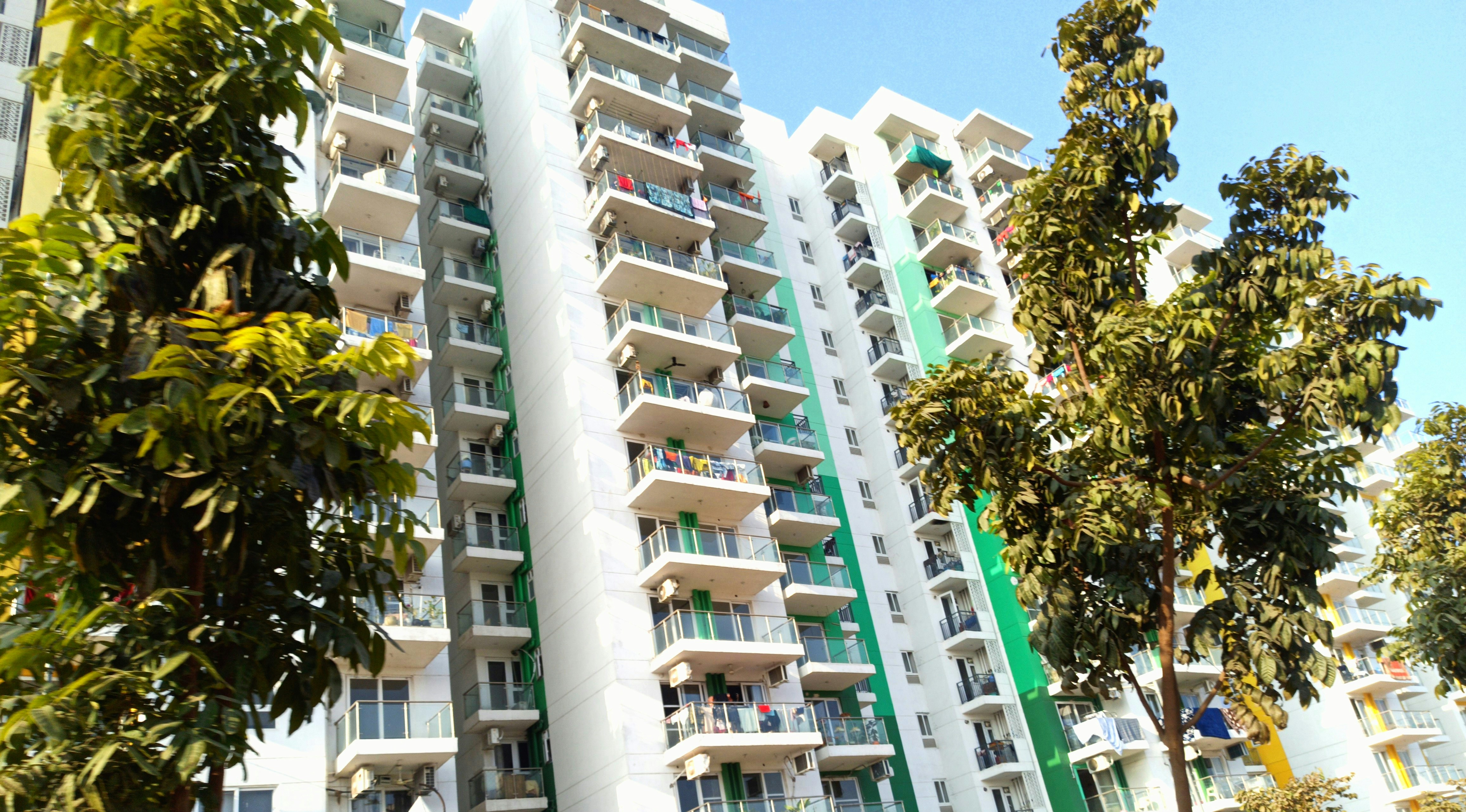 A modern apartment building with balconies and greenery.