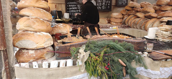 A rustic farmers market stall with a shadowy empty spot, surrounded by curious vendors eyeing a sinister loaf on display.