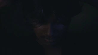 Abstract shadows cast on a face, blending makeup with light and darkness.