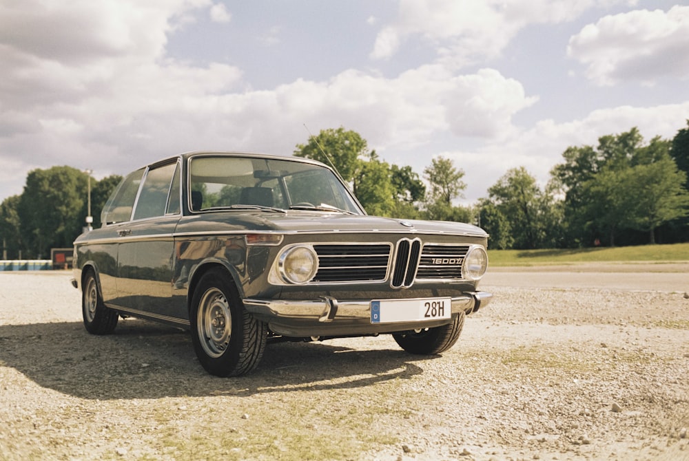 an old bmw is parked in a parking lot