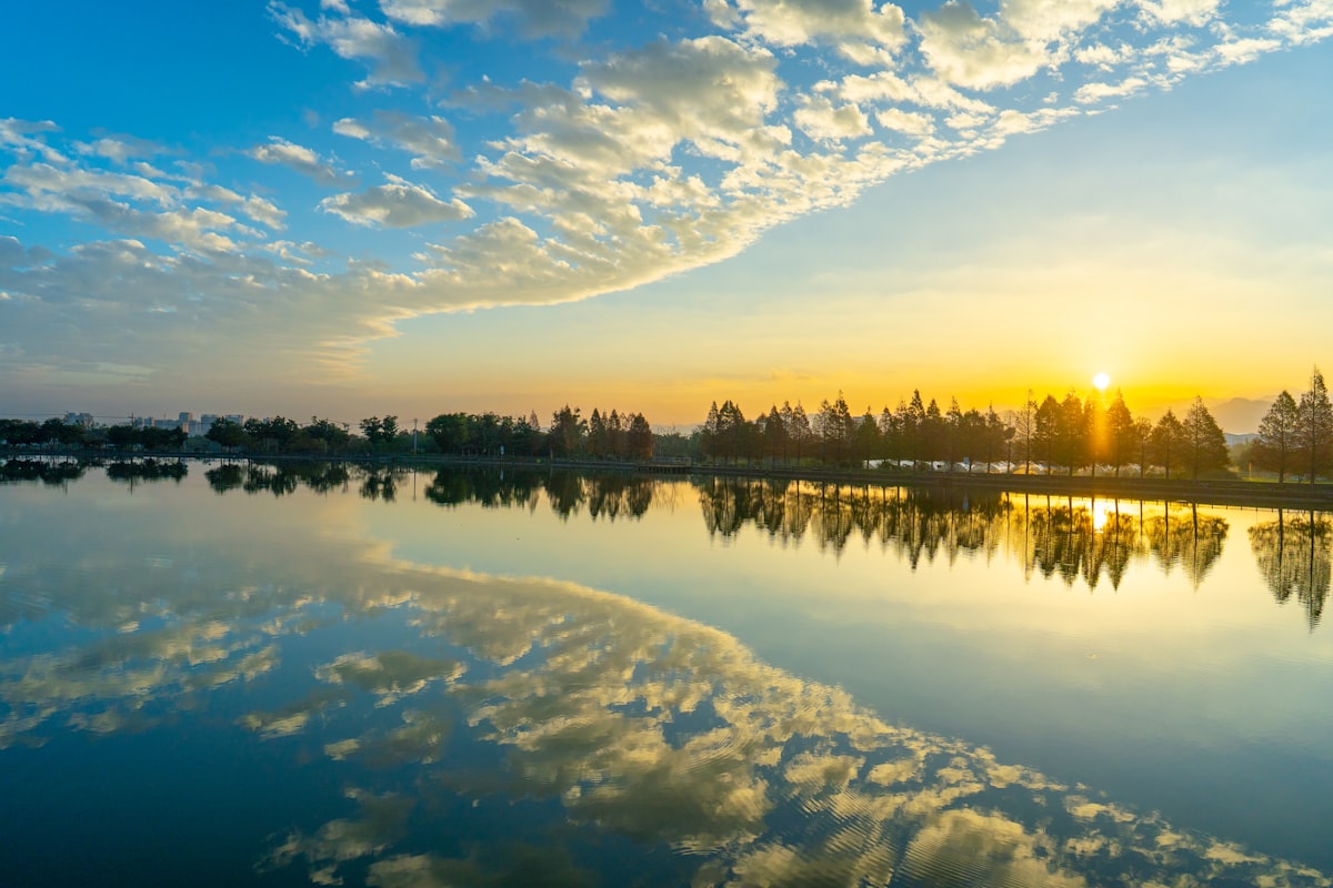 桃园静谧湖面的夕阳余晖，云影倒映水中
