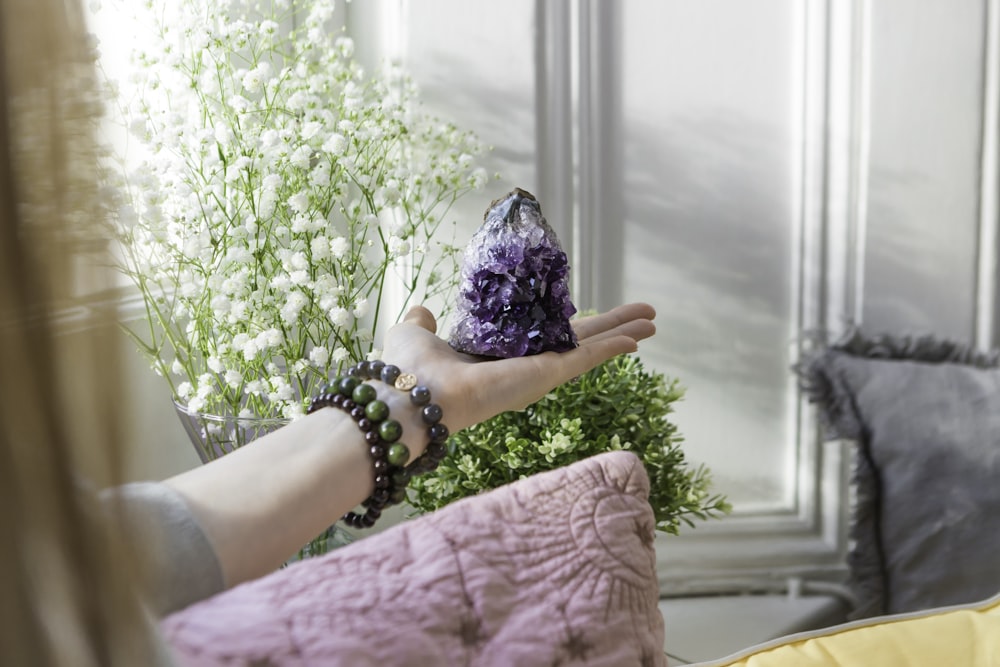 a woman holding a purple stone in her hand