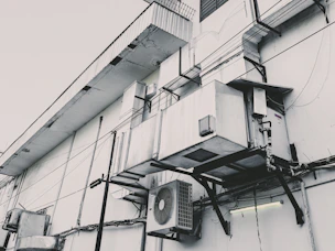 a black and white photo of an air conditioner on the side of a building